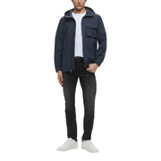 Man in Navy Hooded Jacket and Dark Wash Jeans wearing white sneakers