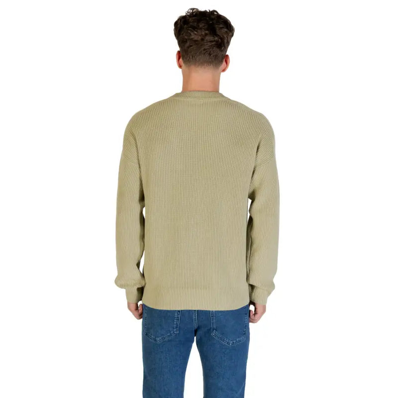 Man wearing Olive Green Ribbed Knit Sweater and jeans in a fashion image