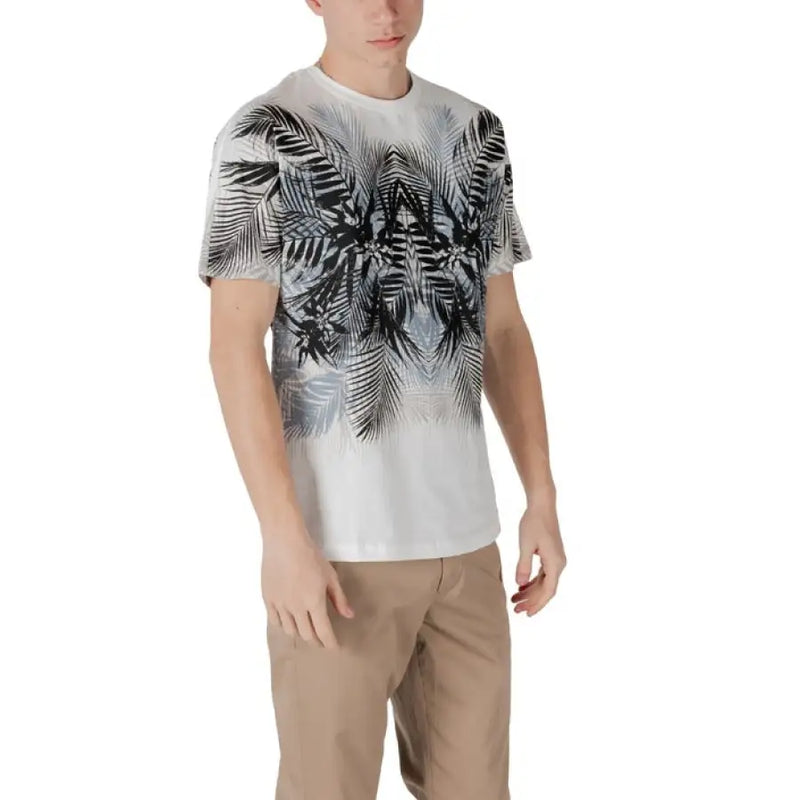 Man wearing a white t-shirt with black and gray palm leaf pattern and khaki pants