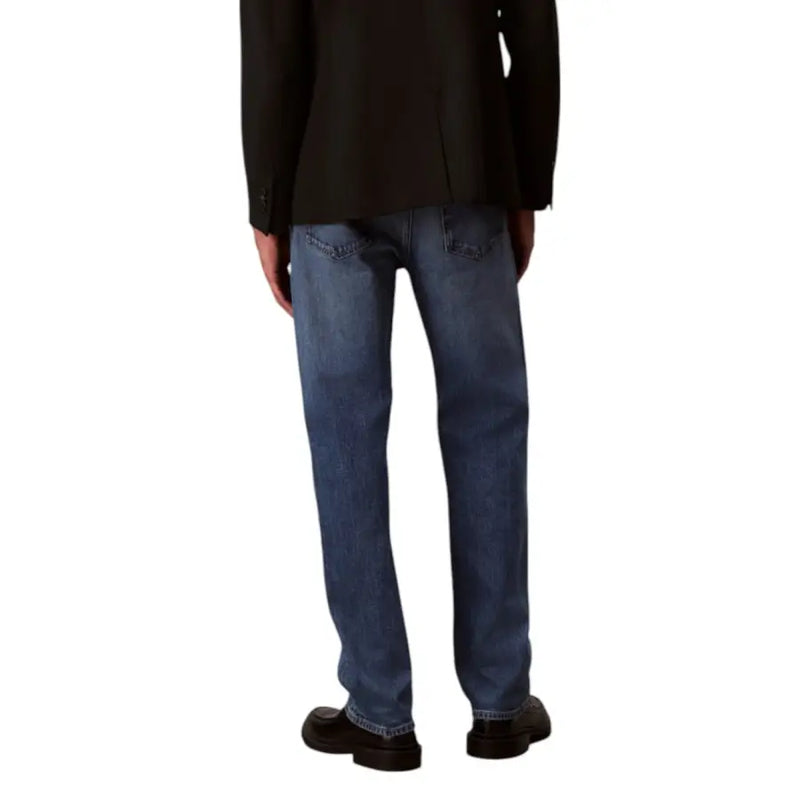 Men’s blue jeans in medium-wash denim with classic straight-leg cut visible stitching and standard back pockets shown from back