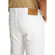 Men’s white denim jeans showing the back side with a tan leather Calvin Klein brand patch on the waistband