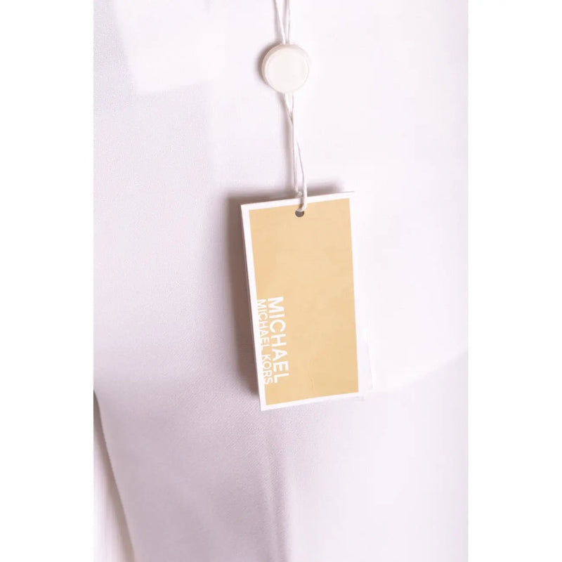 A beige michael kors brand tag with white lettering attached to white stretch womens zip button trousers