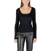Woman wearing Morgan De Toi black long knit sweater with square neckline and leather-look pants
