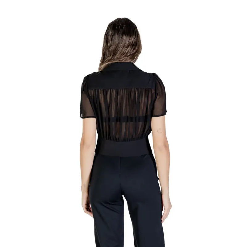 Women wearing Morgan De Toi black V neck blouse with sheer stripes and high-waisted wide-leg pants