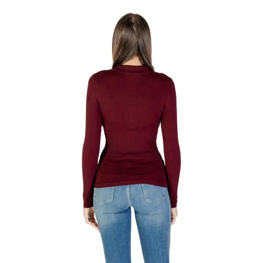 Woman wearing Morgan De Toi Bordeaux long V neck button front knit sweater and blue jeans
