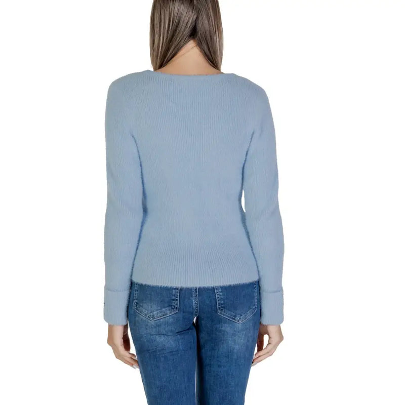 Women wearing Morgan De Toi light blue long V neck ribbed sweater with blue jeans