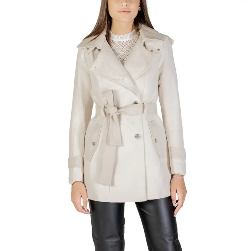 Beige double-breasted trench coat with belt and wide lapels over white lace top and black pants