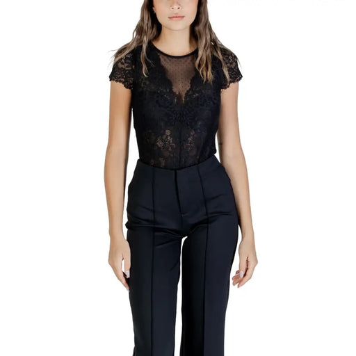 Women wearing a black lace short-sleeve bodysuit paired with high-waisted dress pants
