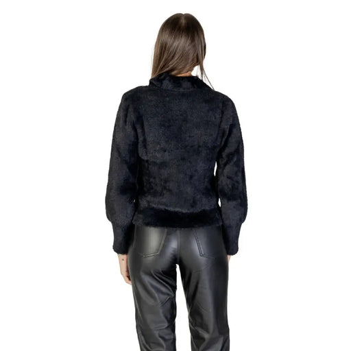 Women wearing Morgan De Toi long black zip knitwear with black faux fur jacket and leather pants