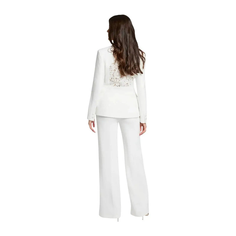 White blazer with intricate beaded back detailing paired with morgan de toi women white wide-leg trousers with zip front pockets viewed from back