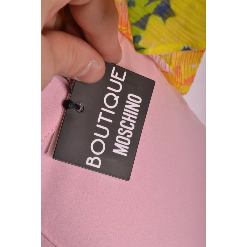 Black rectangular boutique Moschino tag with white lettering on pink Italian made women trousers for spring summer