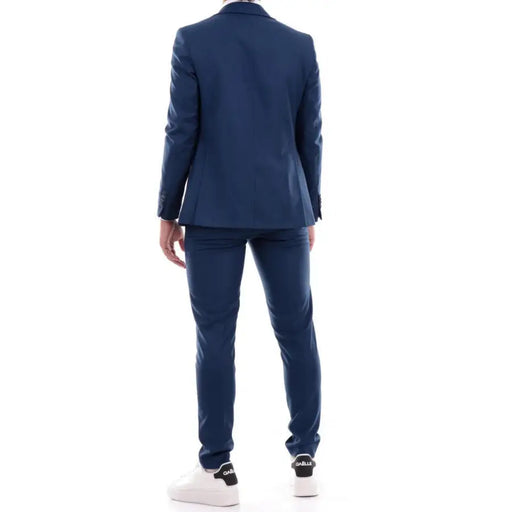 Men’s navy blue slim-fit suit with two-button blazer and white sneakers for spring summer fashion