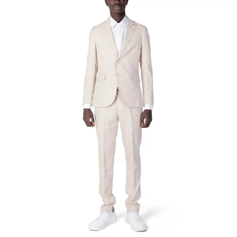 A man wearing a cream-colored Mulish men suit made of beige polyester viscose blend with white dress shirt and matching trousers