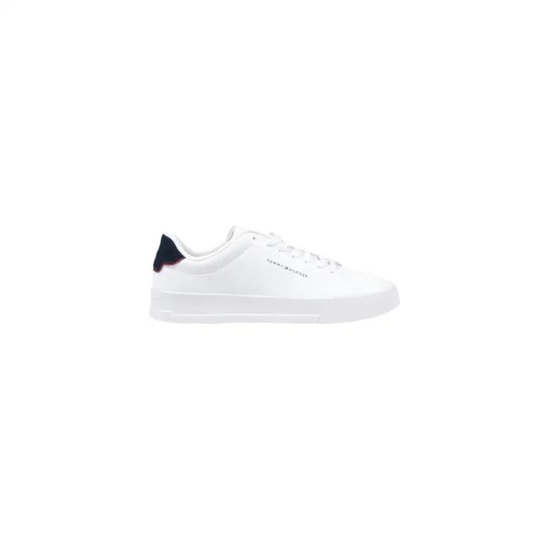 Baskets blanches Tommy Hilfiger avec languette arrière en cuir bleu marine, logo discret sur le côté et semelle blanche.