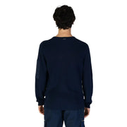 Navy blue ribbed knit long-sleeve sweater with a zippered pocket and contrasting dark patch on the left sleeve