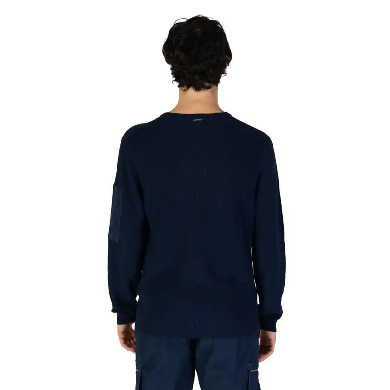 Navy blue ribbed knit long-sleeve sweater with a zippered pocket and contrasting dark patch on the left sleeve