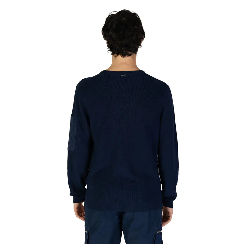 Navy blue ribbed knit long-sleeve sweater with a zippered pocket and contrasting dark patch on the left sleeve