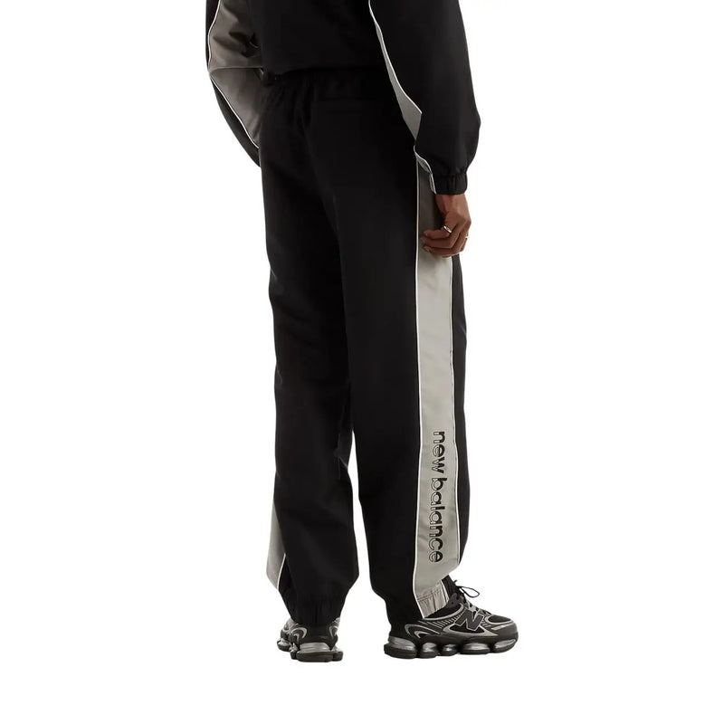 New Balance men trousers black polyester fall winter track pants with vertical gray stripe and black logo lettering