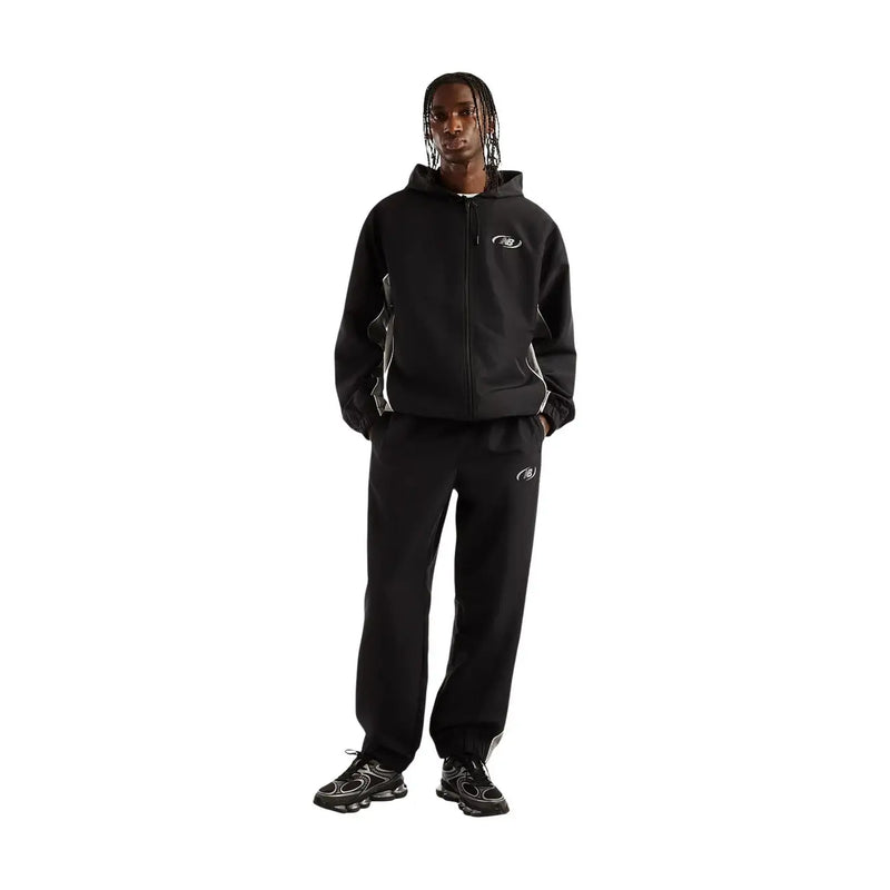Black new balance men trousers made of polyester for fall winter shown with black zip-up hoodie with white logo and accents