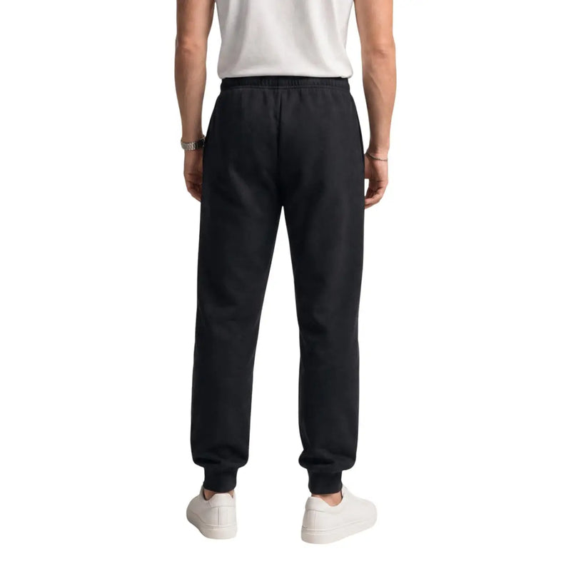 The north face men black cotton fleece jogger trousers with elastic waistband and ribbed cuffs shown from the back