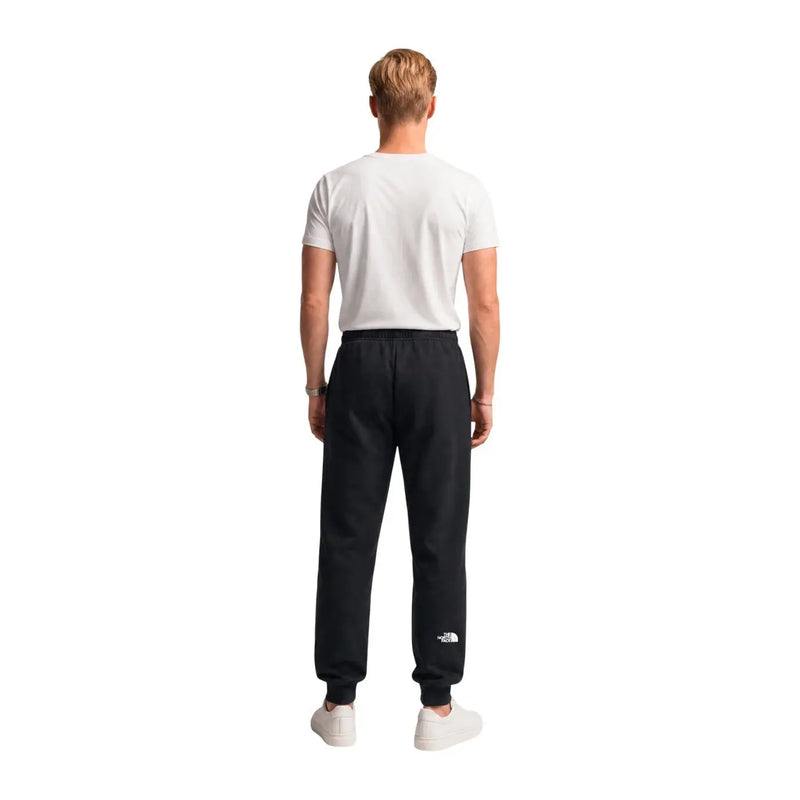 The North Face men black cotton fleece trousers feature a white logo on the lower left leg in jogger style