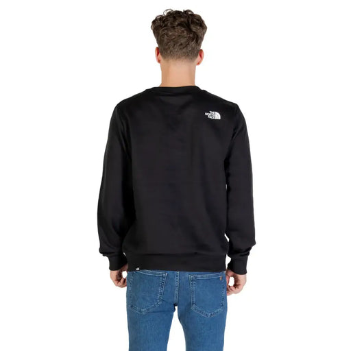 Men’s black crewneck sweatshirt with white logo on upper back from The North Face