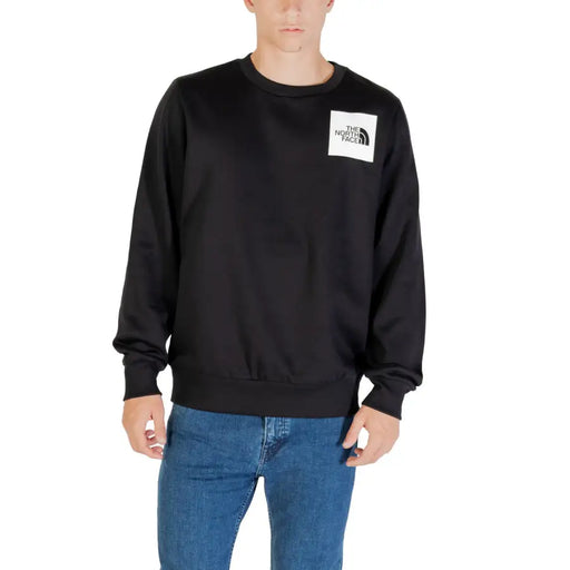 Men’s black crewneck sweatshirt with white square logo patch on chest from The North Face