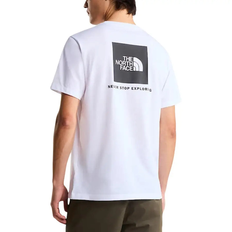 White short-sleeved cotton t-shirt featuring a black square logo with the north face and never stop exploring slogan