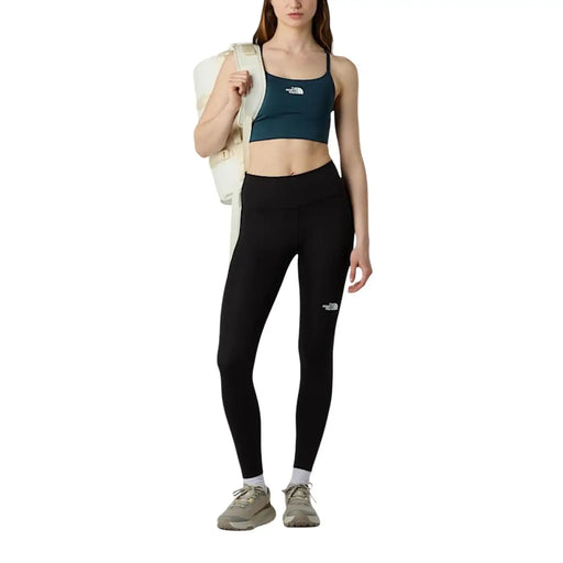 Black high-waisted leggings with white logo on left thigh made of polyester elastane by The North Face women trousers