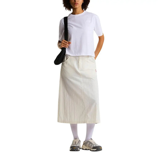 Ein cremefarbener, mittellanger Rock mit lockerer Passform und Falten, kombiniert mit einem weißen T-Shirt aus Baumwollmischgewebe von The North Face für Damen.