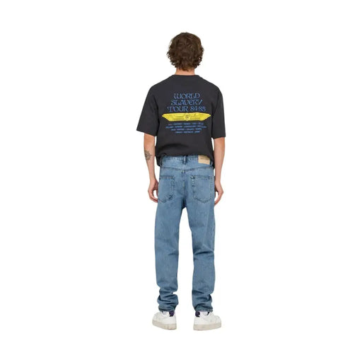 Black short-sleeved cotton t-shirt with world slavery tour 84-85 graphic print paired with light blue Only and Sons jeans