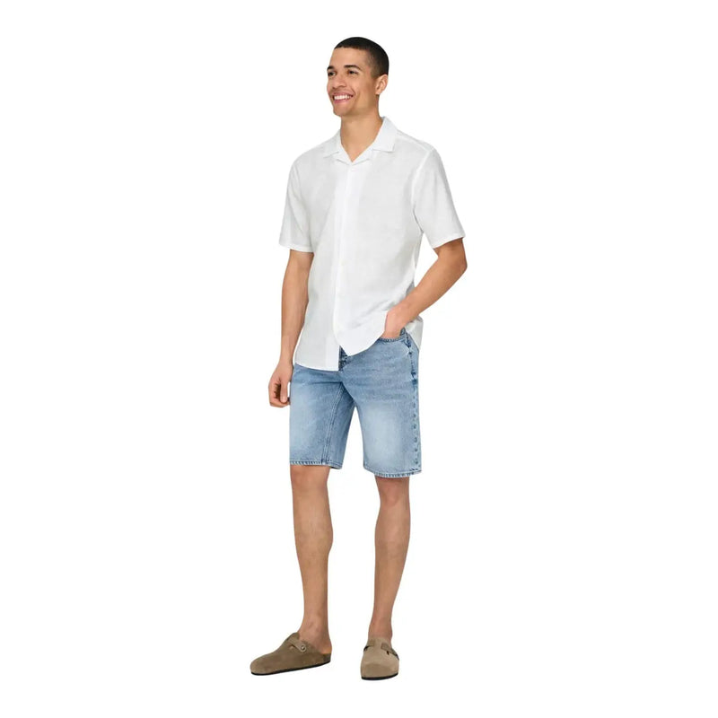 A man wearing only and sons mens white linen blend resort shirt with light-wash denim shorts and brown suede slip-on shoes