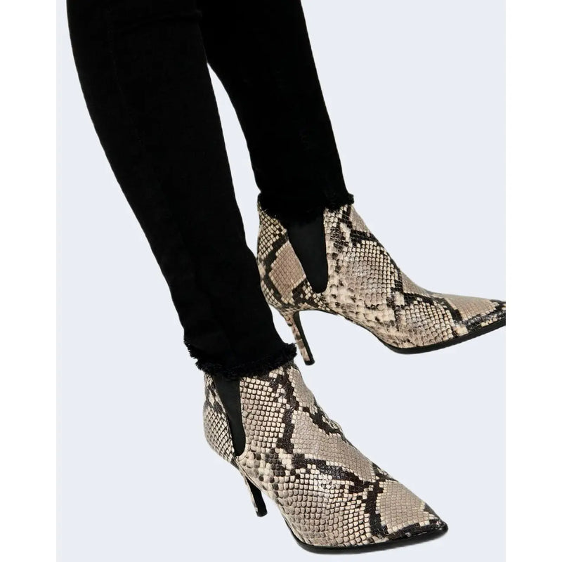 Snake-print ankle boots with sleek pointed toe and slender high heel paired with only women black cotton jeans