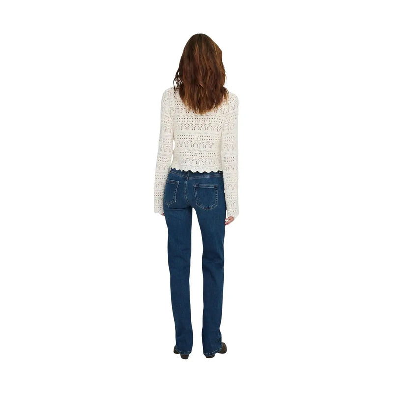 A woman wearing only women blue mid straight jeans cotton denim paired with a cream crochet lace top