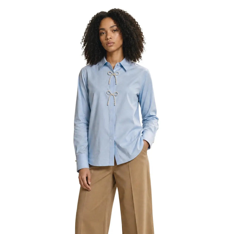 Only women light blue cotton long polo shirt with pearl detail featuring decorative white bow at the front