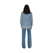 Back view of only women light blue cotton long denim shirt with subtle floral embroidery across the back
