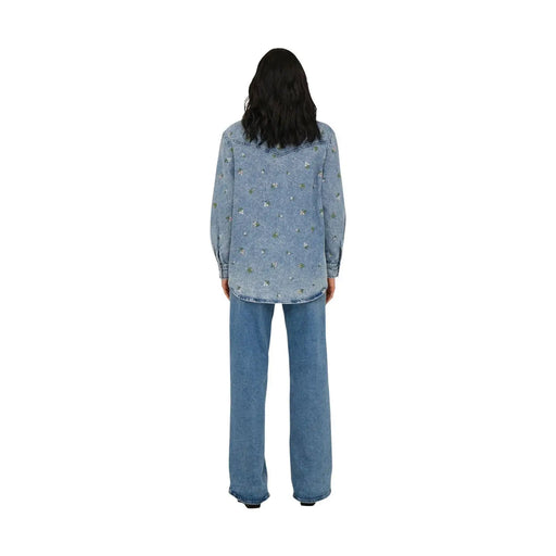Back view of only women light blue cotton long denim shirt with subtle floral embroidery across the back