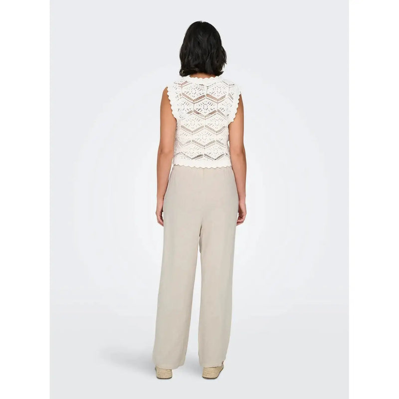 A delicate off-white crochet top with scalloped edge paired with beige linen viscose wide-leg trousers spring summer