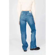 Woman in white top wearing Calvin Klein blue denim jeans