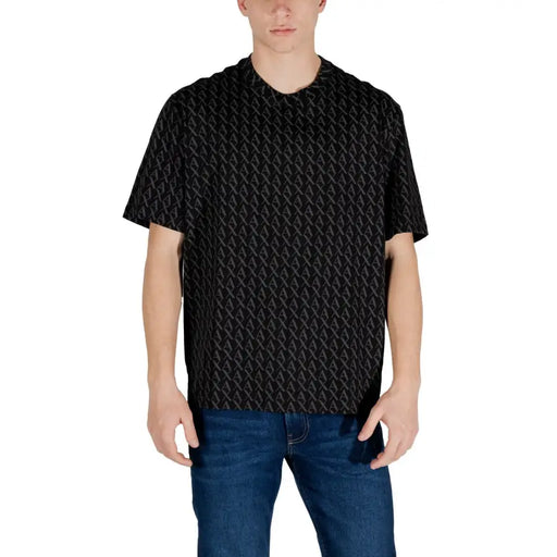 Men’s short-sleeved black collared shirt with subtle pattern paired with blue jeans