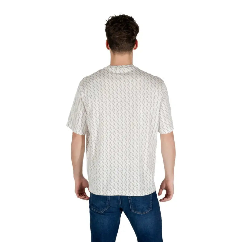 Ein Mann, der ein weißes, gemustertes Kurzarm-T-Shirt mit einem dezenten hellgrauen geometrischen Muster trägt.