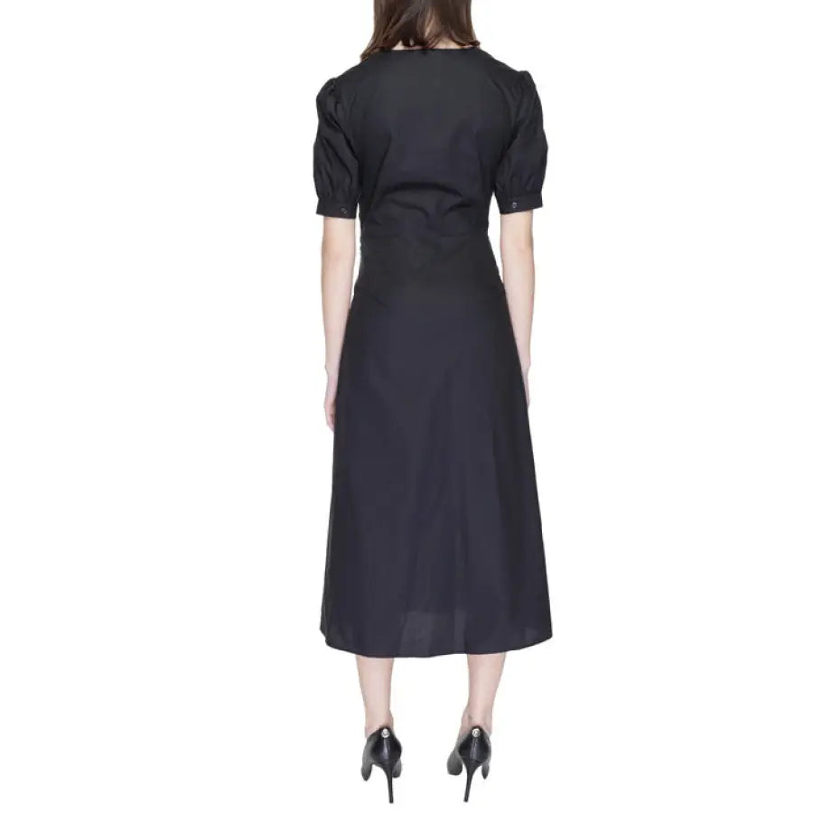 Woman in black Alviero Martini Prima Classe dress, showcasing luxury fashion