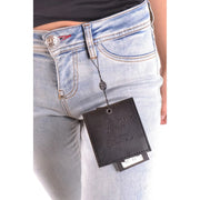 Schwarzes Lederetikett mit geprägtem Philip Plein Couture-Logo hängt an einer hellblauen Baumwolljeans.