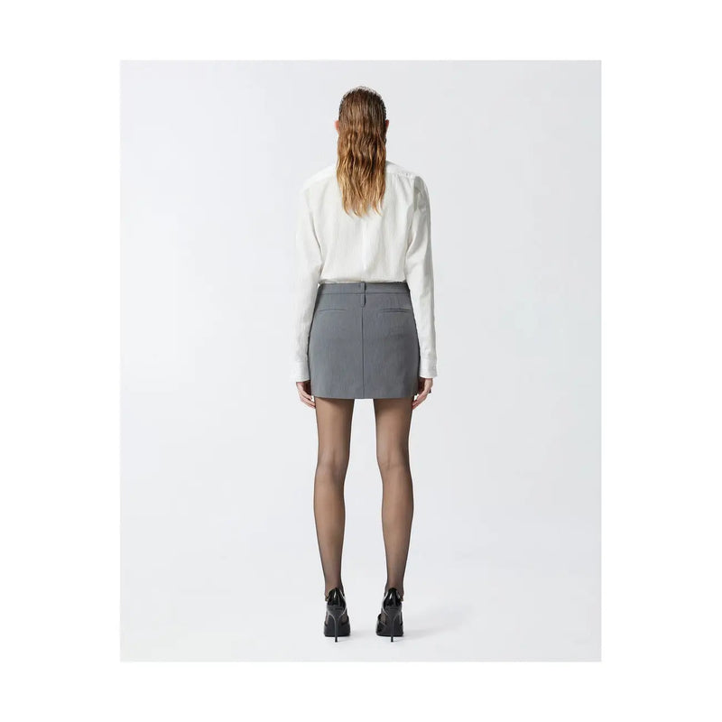 Pinko grey tailored mini skirt with structured waistband and front pockets worn with white blouse and black heels