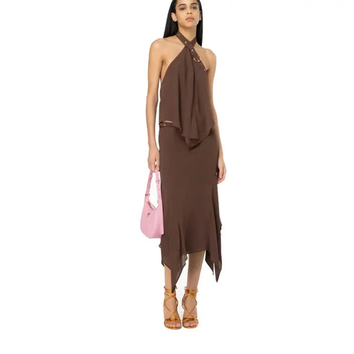 Women wearing a brown halter neck top, matching asymmetric midi skirt, pink shoulder bag, and brown lace-up sandals