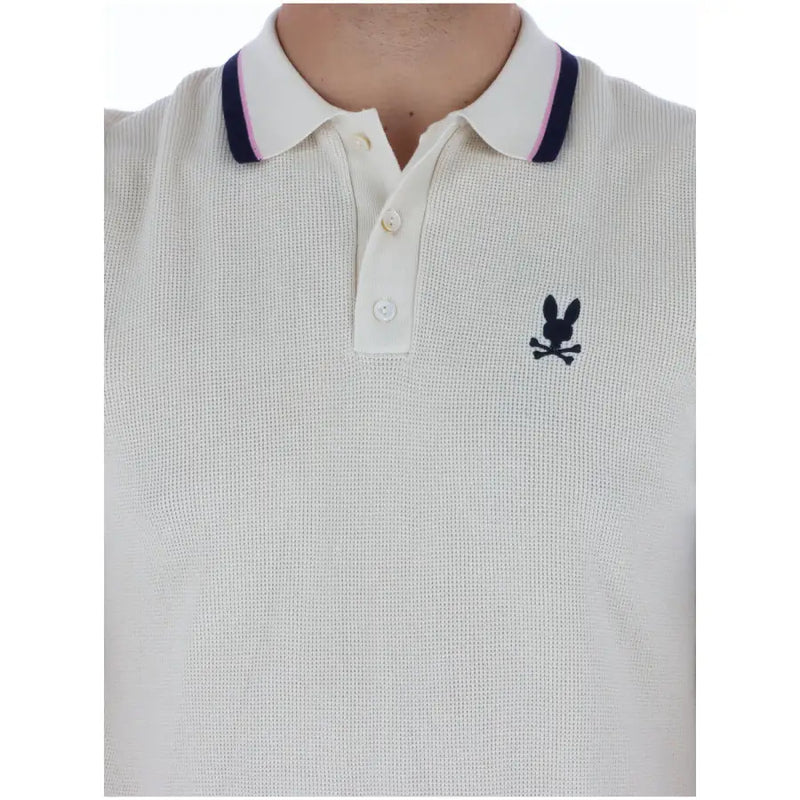 Cream-colored cotton psycho bunny men polo shirt with navy pink collar trim and black embroidered logo short sleeve