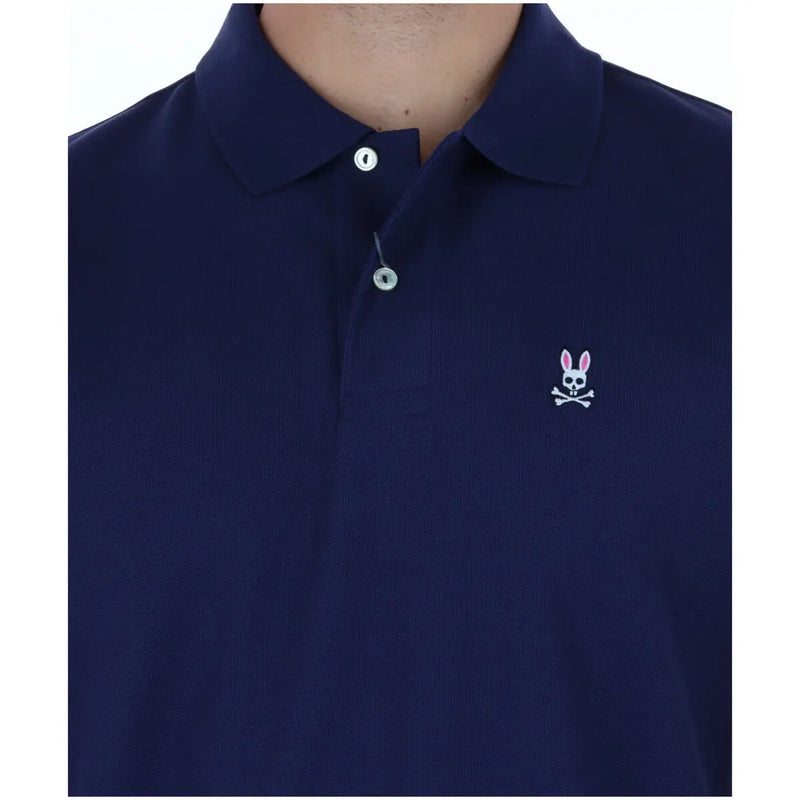 Psycho Bunny polo for men in navy blue with white embroidered rabbit skull and crossbones logo, front view