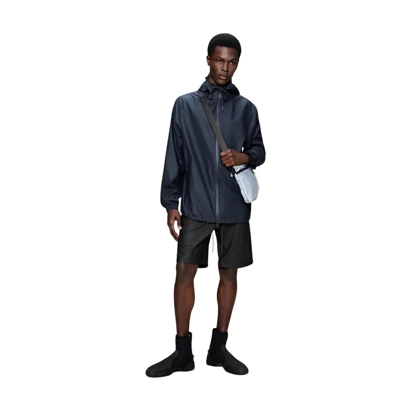 Veste blazer imperméable à capuche pour homme Rains, bleu marine foncé, avec une finition élégante en polyester résistant à l'eau et des détails de fermeture éclair discrets.