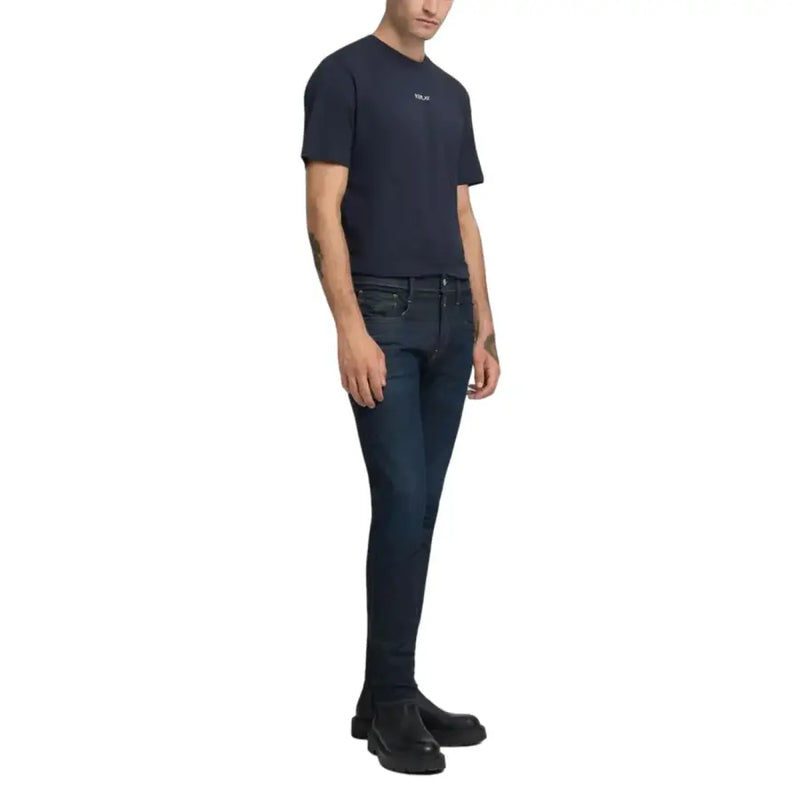 Dunkelblaue Slim-Fit-Jeans mit dezenter Used-Optik und schwarze Lederschuhe.