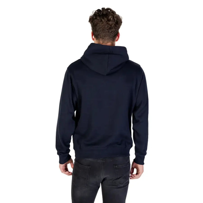 Men’s dark blue hooded sweatshirt with front pocket paired with black jeans
